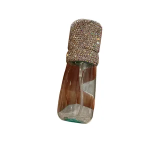 Elegant luxury clear refillable spray bottle with sparkling rhinestone cap detail