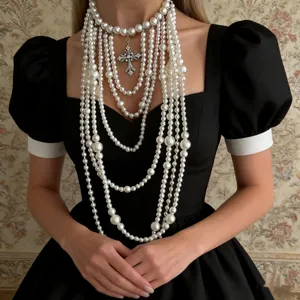 Detalle de un elegante collar de perlas barrocas francesas de varias capas con cruz vintage.