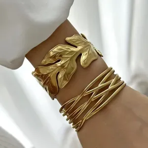 Dettaglio del bracciale a foglia dorata e del bracciale a onde multifilo al polso