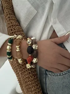 Detailansicht von drei retro-unregelmäßigen Acryl- und goldenen CCB-Perlenarmbändern.