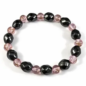 Detailaufnahme eines Perlenarmbands aus Hämatit und leuchtendem rosa Glas auf Weiß