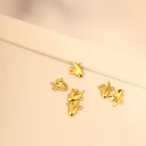 Nahaufnahme von kleinen Goldfisch-Anhängern für DIY-Schmuck und Ozean-Themen-Zubehör