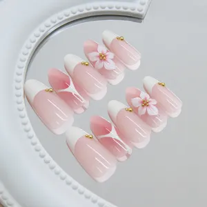 Detail van 3D bloem French amandel plaknagels met een elegant crème wit verloop.