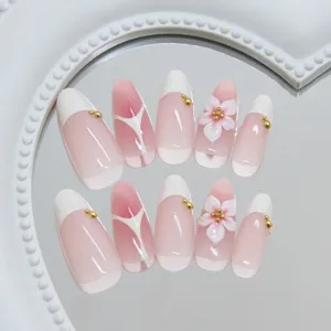 Detailweergave van amandel kunstnagels met 3D bloemen en French tip design