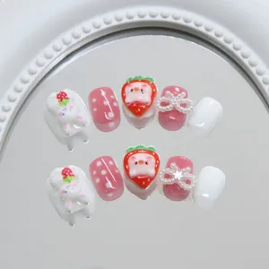 Detail of handmade press-on nails with cute rabbit, strawberry pig, and pearl bows
