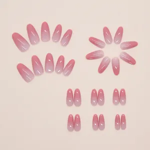 Gros plan détaillé de faux ongles amande dégradés rose avec une finition brillante