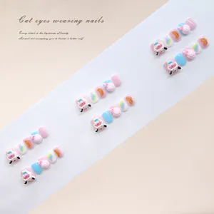 Detailed view of handmade cute cow and candy themed press-on nails for children