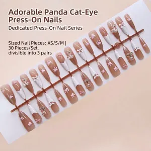 Detail view of pink cat-eye press-on nails set with cute bear and bow decorations