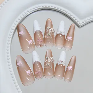Close-up of pink cat-eye press-on nails with cute 3D bear charms and white polka dots.
