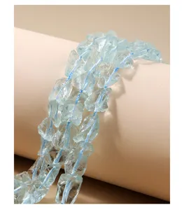 Nahaufnahme von unregelmäßigen blauen Rohkristallperlen mit natürlicher Textur und Faden.