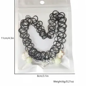 Detail of glow-in-the-dark Halloween choker with bat and cross charms in 11x8cm packaging