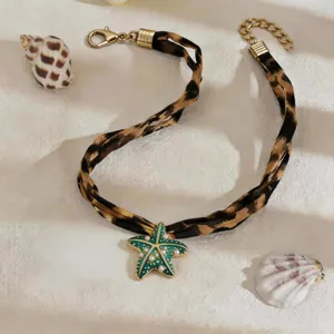 Gedetailleerde weergave van groene zeester hanger aan luipaardprint choker ketting