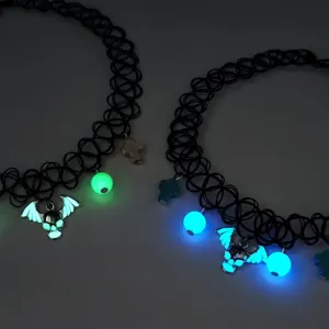 Detail of Halloween luminous chokers with green and blue glowing bat skull pendants