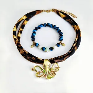 Detail shot of luminous octopus pendant necklace and blue cat's eye beaded bracelet set.
