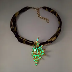 Detailed view of a luminous gold conch shell pendant necklace with leopard strap