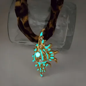 Detailed macro view of glowing golden conch pendant necklace in dark environment