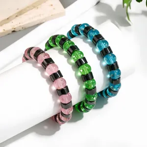 Detail von leuchtenden Glasur- und Hämatit-Perlenarmbändern in Rosa, Grün und Blau