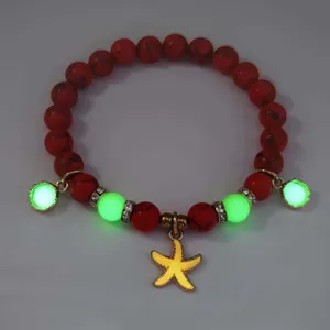 Macro detail showing the glowing effect of a luminous starfish charm beaded bracelet.