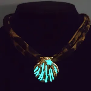 Close-up of luminous shell pendant necklace with pearls and glowing star detail