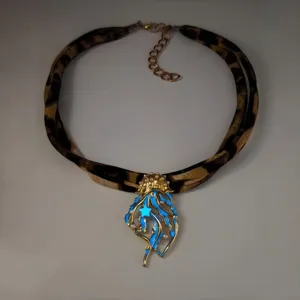 Detailed view of luminous jellyfish pendant with leopard print ribbon and pearls