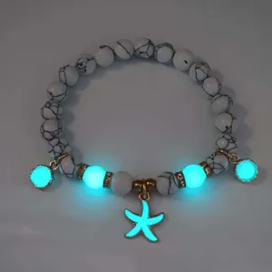 Detailed view of luminous beaded bracelet featuring glowing cyan starfish charms