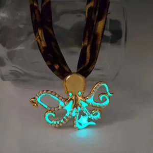 Luminous octopus pendant necklace with leopard print ribbon strap and cyan glow