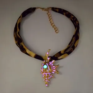 Luminous conch necklace with leopard print band and glowing gold seashell pendant.