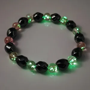 Detaillierte Detailaufnahme leuchtender Glasperlen an einem schwarzen Hämatit-Armband