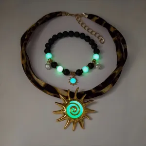Close-up of luminous sun pendant necklace and bracelet set with vibrant glowing effect