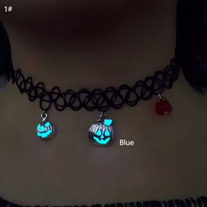 Macro detail shot showing blue glow-in-the-dark pumpkin charms on a black choker necklace