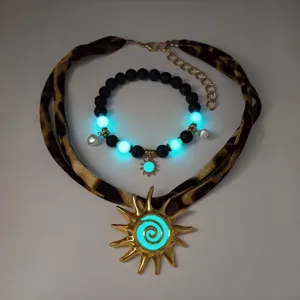 Detail of luminous jewelry set with leopard strap and gold sun pendant glowing in blue.