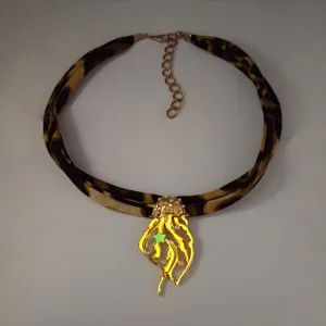 Close-up of leopard print ribbon necklace with a glowing jellyfish pendant and pearls.