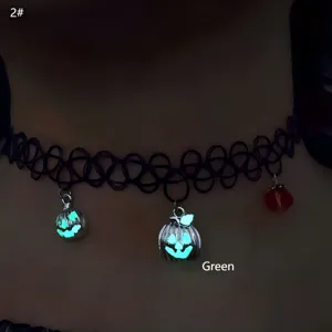 Close-up of black elastic choker with glowing green pumpkin charms for Halloween.