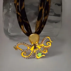 Detailed view of a gold octopus necklace featuring a luminous star and pearls