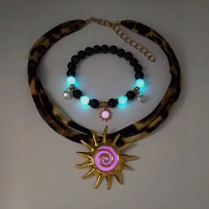 Detailed view of luminous beach jewelry set with gold sun pendant and glowing beads