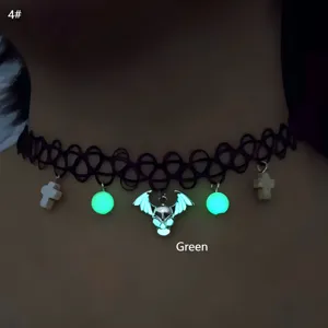Detailed view of luminous green skull and cross pendants on black fishline choker