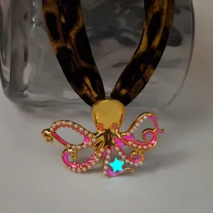 Close-up of gold octopus necklace with glowing star and leopard print strap