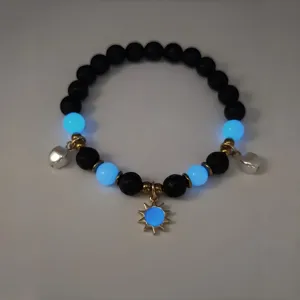 Detailed macro shot of glowing blue beads and sun charm on black beach style bracelet