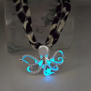 Close-up detail showing the glowing blue luminous effect of the octopus pendant metal