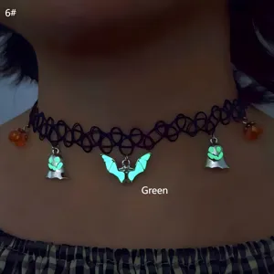 Close-up of Halloween elastic choker with luminous green ghost and bat charms.