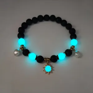 Close-up detail of luminous blue beads and gold sun charm on a stylish beach necklace