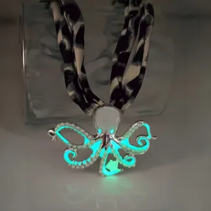 Detail shot of glow-in-the-dark octopus pendant necklace with leopard pattern strap