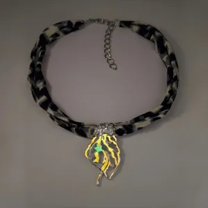 Detailed view of a luminous jellyfish pendant necklace with a leopard print ribbon strap