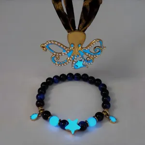 Macro view of luminous octopus pendant and star charm beaded bracelet set for beach