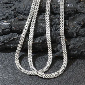 Close-up of a stainless steel double row Franco chain necklace with polished silver finish