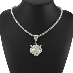 Close-up van de iced out tijgerkop hanger aan een sprankelende zilveren tennisketting.