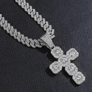 Detailed close-up of iced out cross pendant and silver Cuban chain for hip hop style