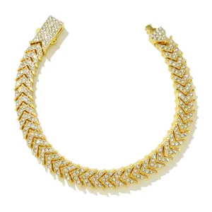Nahaufnahme eines goldfarbenen Iced Out Fishtail Tennisarmbands mit klaren Strasssteinen