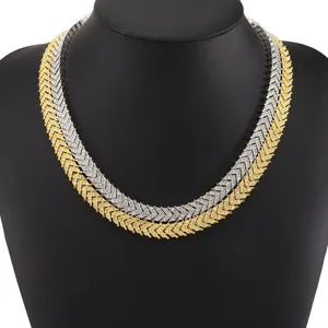 Nahaufnahme von gold- und silbernen Iced-Out-Fischgrätenketten auf einer schwarzen Büste.