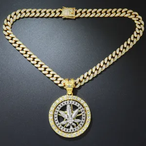 Close-up of iced out spinning maple leaf pendant on a thick gold Cuban link chain.